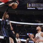 El pívot de los Orlando Magic Wendell Carter Jr. (34) hace un mate delante del escolta de los Cleveland Cavaliers Ty Jerome, a la derecha, en la segunda mitad de un partido de baloncesto de la NBA el domingo 16 de marzo de 2025, en Cleveland.