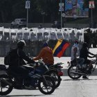 Manifestantes conducen sus motocicletas frente a miembros de la Guardia Nacional Bolivariana durante una protesta contra el gobierno de Nicolás Maduro en Caracas