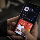 Una periodista de AFP comprueba la aplicación de entrega de comida a domicilio DoorDash en su smartphone el 27 de febrero de 2020 en Washington, DC. DoorDash inició el 27 de febrero de 2020 el proceso de salida a bolsa con una oferta de acciones en Estados Unidos que podría valorar el popular servicio de entrega de comida a domicilio en más de 10.000 millones de dólares.