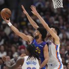 El escolta de los Nuggets de Denver Jamal Murray, atrás a la izquierda, sube a canasta mientras el escolta de los Thunder de Oklahoma City Cason Wallace, delante, y el alero Chet Holmgren defienden en la segunda mitad del tercer partido de las semifinales de la Conferencia Oeste de los playoffs de baloncesto de la NBA, el viernes 9 de mayo de 2025, en Denver.