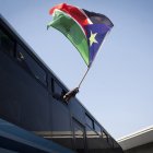 Un refugiado de Sudán del Sur ondea su bandera nacional