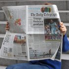 Un lector hojea un ejemplar de The Telegraph