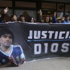 Fans del fallecido astro del fútbol Diego Maradona sostienen una pancarta que dice en español "Justicia por Dios" frente al tribunal donde los miembros del equipo médico que trató a Maradona van a juicio por presunto homicidio por negligencia en San Isidro en las afueras de Buenos Aires