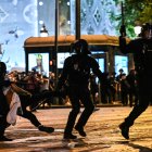 Agentes de la policía antidisturbios detienen a una persona durante las celebraciones en París