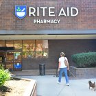 Una mujer entra en una farmacia Rite Aid con su mascota