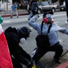 Esta foto tomada el 8 de junio de 2025 muestra a manifestantes lanzando tinta a los agentes de la Patrulla de Carreteras de California durante una manifestación tras las operaciones federales de inmigración en Los Ángeles.