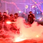 Fuegos artificiales explotan alrededor de agentes de policía con equipo antidisturbios durante una protesta en respuesta a las operaciones federales de inmigración en el barrio de Little Tokyo, en el centro de Los Ángeles, el 9 de junio de 2025. La administración del presidente Donald Trump dijo el 9 de junio que enviaba 700 marines estadounidenses y miles de efectivos más de la Guardia Nacional a Los Ángeles, lo que provocó una furiosa respuesta del gobernador de California por el "desquiciado" despliegue. Las protestas en Los Ángeles, hogar de una gran población latina, estallaron el 6 de junio, desencadenadas por redadas de inmigración que se saldaron con decenas de detenciones de lo que las autoridades dicen que son migrantes ilegales y miembros de bandas.