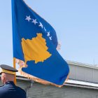 Un militar ondea la bandera de Kosovo