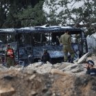 Israeli security and emergency service members deploy at the impact site of an Iranian missile at a bus depot in Herzliya near Tel Aviv on June 17, 2025.