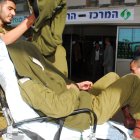 Un soldado israelí herido se cubre la cara al llegar al hospital Beershevas Soroka tras la explosión de un jeep del ejército en el paso fronterizo de Kissufim, entre Israel y la Franja de Gaza, el 27 de enero de 2009, en la que murió un soldado y otros tres resultaron heridos.