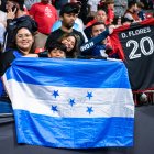 Aficionados hondureños sostienen la bandera de Honduras