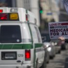 Una ambulancia pasa cerca de una manifestación a favor del Madicare