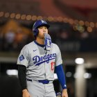 La superestrella japonesa de los Dodgers de Los Ángeles SHOHEI OHTANI (17) camina hacia el banquillo con el guante de bateo en la boca después de la tercera entrada contra los Rays de Tampa Bay el viernes.