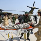 Personal de seguridad talibán transportan a una víctima del terremoto