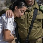 Un soldado del ejército israelí consuela a una mujer durante un funeral.