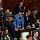 Sanae Takaichi, en el centro, líder del gobernante Partido Liberal Democrático, en pie mientras Takaichi era elegida nueva primera ministra de Japón durante la sesión extraordinaria de la cámara baja, en Tokio, Japón.