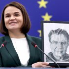 La líder de la oposición bielorrusa S. Tsikhanovskaya con una foto de Andrzej Poczobut.