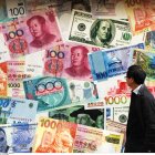 El 12 de marzo de 2015, se observa una combinación de billetes de yuan (RMB), dólar estadounidense, dólar de Hong Kong y otras divisas frente a una casa de cambio en Hong Kong. China está en conversaciones con el Fondo Monetario Internacional (FMI) para que esta institución con sede en Washington incluya el yuan en su cesta de monedas de reserva, según declaró el jueves un alto funcionario bancario, en un intento de Pekín por otorgarle un mayor protagonismo global a la moneda. El vicegobernador del banco central, Yi Gang, afirmó que China espera que el yuan se convierta en parte de los derechos especiales de giro (DEG) del FMI en un futuro próximo.