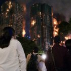 Varias personas observan el incendio en un complejo residencial de Hong Kong