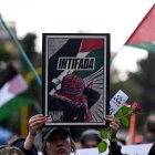 A demonstrator holds a banner that reads 'Intifada'