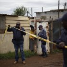 South African Police Service (SAPS) officers put up crime scene tape at the scene of an attack at a tavern in Bekkersdal on December 21, 2025. Nine people were killed when gunmen opened fire at a bar outside Johannesburg early on December 21, 2025.
Ten more were wounded in the early morning attack at the tavern at Bekkersdal, in a gold mining area around 40 kilometres (25 miles) southwest of the city. (Photo by EMMANUEL CROSET / AFP)