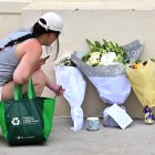 Una mujer coloca flores frente al Bondi Pavilion/ Saeed Khan