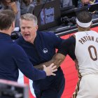 El entrenador jefe de los Golden State Warriors, Steve Kerr, es sujetado por Gary Payton II #0 mientras protesta por una falta no pitada durante el partido de la temporada regular de la NBA 2025 contra los Los Angeles Clippers el lunes 5 de enero de 2026 en el Intuit Dome Arena de Inglewood, California.