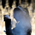 Una joven fuma un cigarrillo electrónico