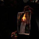 Un manifestante quema una imagen del ayatolá Ali Jamenei