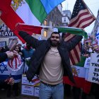 Un manifestante rompe la bandera de la República Islámica de Irán.