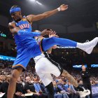 El escolta del Oklahoma City Thunder, Shai Gilgeous-Alexander, delante, salta por encima del alero del San Antonio Spurs, Lindy Waters III, detrás, mientras defiende un tiro durante la primera mitad de un partido de baloncesto de la NBA el martes 13 de enero de 2026 en Oklahoma City.