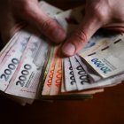 (Archivo) Una manos sostiene billetes argentinos