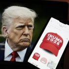 Esta fotoilustración, tomada el 24 de abril de 2025 en Washington, D.C., muestra una imagen del presidente estadounidense Donald Trump junto a un teléfono inteligente con una gorra roja con la leyenda "Trump 2028" en la página web de Trump Store. La tienda en línea de Donald Trump vende ropa con la inscripción "Trump 2028", el año de las próximas elecciones presidenciales estadounidenses
