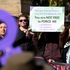 Personas sostienen pancartas y banderas en una manifestación de Women Will Speak en Melbourne el 16 de agosto de 2025, lamentando la erosión de los derechos de las mujeres ante las reivindicaciones de identidad transgénero.