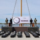 Mexican Navy soldiers standing next to seized packages of cocaine