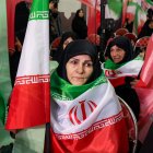 Mujeres con banderas iraníes de luto por las víctimas del terrorismo fallecidas en las protestas en Irán