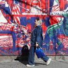 Una mujer iraní pasa junto a un mural que sataniza las conversaciones entre Irán y EEUU
