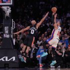 Jalen Brunson, de los New York Knicks, derecha, lanza por encima de Jordan McLaughlin