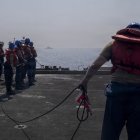 Marineros de la Armada de los Estados Unidos se preparan para tirar de una cuerda durante un reabastecimiento en el mar en la cubierta de vuelo del portaaviones clase Nimitz USS Abraham Lincoln (CVN 72) durante la Operación Epic Fury, el 10 de marzo de 2026. (Foto de la Armada de los Estados Unidos)