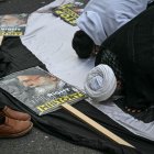 Pro-Iran regime supporters pray on the sidelines of an annual protest, this year a static protest