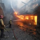Un bombero del Departamento de Bomberos de Long Beach rocía con agua un edificio de apartamentos en llamas en el incendio de Eaton en Altadena en 2025