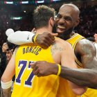 El base de los Lakers de Los Ángeles, Luka Doncic (77), y el alero LeBron James, a la derecha, se abrazan tras derrotar a los Miami Heat en un partido de baloncesto de la NBA, el jueves 19 de marzo de 2026, en Miami. (Foto AP/Lynne Sladky)