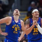 Denver Nuggets forward Aaron Gordon, right, waits to see if he would be called for a foul as center Nikola Jokic looks on the overhead scoreboard in the second half of an NBA basketball game against the Portland Trail Blazers Sunday, March 22, 2026, in Denver. (AP Photo/David Zalubowski)