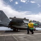 Un marinero da la señal para el lanzamiento de un E/A‑18 Growler.