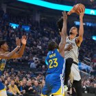 El alero de los San Antonio Spurs, Victor Wembanyama (1), lanza por encima de Draymond Green (23) y Nate Williams (19), de los Golden State Warriors, durante la primera parte de un partido de baloncesto de la NBA disputado en San Francisco el miércoles 1 de abril de 2026.