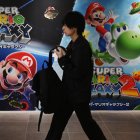Un hombre pasa junto a carteles de Super Mario Galaxy en la tienda Nintendo de Tokio
