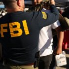 A student tries on a Federal Bureau of Investigation (FBI) vest while learning about jobs with the agency during the 10th annual Aviation Career Day at Los Angeles International Airport (LAX) in Los Angeles, California on October 30, 2025. (Photo by Patrick T. Fallon / AFP)