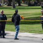 Un hombre lleva flores mientras agentes de la policía de San Diego bloquean el acceso