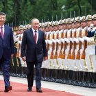 En esta fotografía de agencia distribuida por la agencia estatal rusa Sputnik, el presidente de Rusia, Vladímir Putin (centro), y el presidente de China, Xi Jinping (izquierda), pasan revista a la guardia de honor durante una ceremonia de bienvenida celebrada en el Gran Salón del Pueblo de Pekín el 20 de mayo de 2026. (Foto de Alexander KAZAKOV / POOL / AFP)