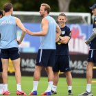 El delantero inglés n.º 9, Harry Kane (C), habla con sus compañeros de equipo mientras el seleccionador alemán de Inglaterra, Thomas Tuchel (D), observa la escena durante una sesión de entrenamiento en el marco de la preparación del equipo para su primer partido del Mundial de fútbol contra Croacia, en la concentración del equipo en Palm Beach Gardens, el 9 de junio de 2026.